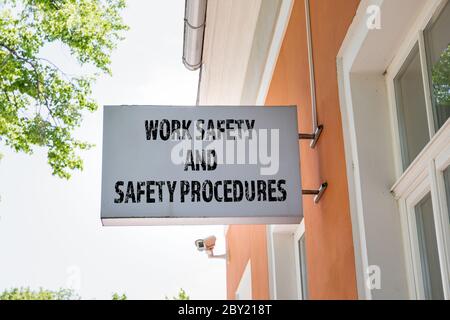 CONCETTO DI SICUREZZA SUL LAVORO E PROCEDURE DI SICUREZZA. Banner pubblicitario e telecamera di sicurezza sulla parete dell'edificio Foto Stock