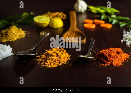 Gli ingredienti alimentari ben guarniti sul piano della tavola includono varie spezie come peperoncino, limone, foglie di curry, zenzero, aglio, gamberi, cucchiai ecc. Foto Stock