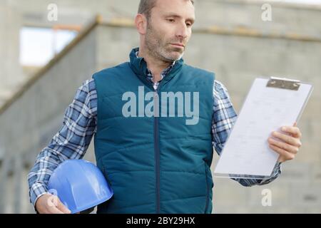 costruttore che prepara stima per miglioramento esterno domestico Foto Stock