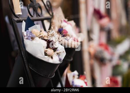 Piccolo bouquet di fiori all'interno di un secchio di vernice nero. Foto Stock