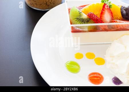 crema di fragole e una tazza di tè e caffè su sfondo di legno, fuoco selettivo Foto Stock