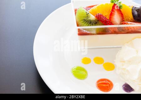 crema di fragole e una tazza di tè e caffè su sfondo di legno, fuoco selettivo Foto Stock