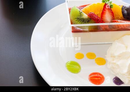 crema di fragole e una tazza di tè e caffè su sfondo di legno, fuoco selettivo Foto Stock