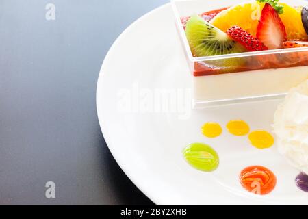 crema di fragole e una tazza di tè e caffè su sfondo di legno, fuoco selettivo Foto Stock