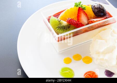 crema di fragole e una tazza di tè e caffè su sfondo di legno, fuoco selettivo Foto Stock