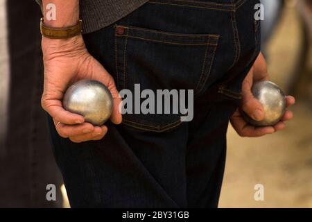 L'uomo tiene boule di metallo durante la partita di Petanque, Francia Foto Stock