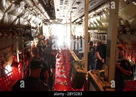 L'interno di un Royal Australian Air Force Lockheed C-130 Hercules in cui vengono abbandonati nuovi vigili del fuoco e vengono recuperati i vigili del fuoco stanchi. Foto Stock