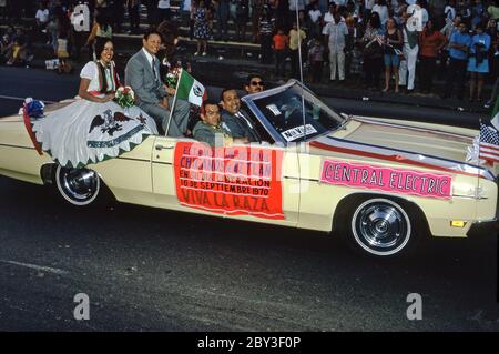 Un'auto in una sfilata della comunità di Chicano a Los Angeles, California, USA 1970 (Chicanos e Chicanas sono uomini e donne di origine messicana). Un cartello sul lato della vettura sponsorizzata indica (in spagnolo) orgoglio per la loro cultura ('viva la Razia' – Long Live the Race). La Giornata dell'Indipendenza (Día de la Independencia) è una festa pubblica in Messico il 16 settembre per celebrare la liberazione dal dominio spagnolo nel 1810. Una bandiera messicana vola accanto a una donna in abito tradizionale. Foto Stock