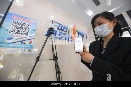 Pechino, la provincia cinese di Zhejiang. 2 Apr 2020. Un membro dello staff visualizza un codice QR sanitario all'ingresso di un edificio di uffici nel distretto di Yuhang di Hangzhou, provincia di Zhejiang, nella Cina orientale, il 2 aprile 2020. PER ANDARE CON XINHUA TITOLI DEL 9 GIUGNO 2020 credito: Xu Yu/Xinhua/Alamy Live News Foto Stock