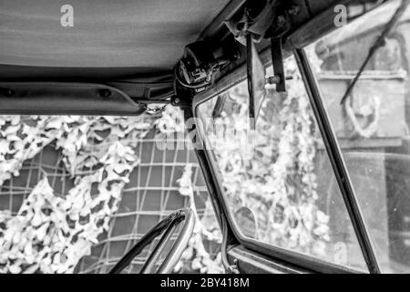 Vista monocromatica di un noto veicolo militare della seconda guerra mondiale con guida a sinistra che mostra parte dello sterzo e la parte superiore in tela. Foto Stock