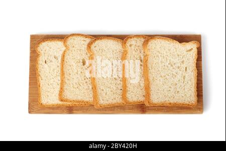 il pane fresco fatto con farina di grano bianco viene tagliato a fette su un pannello di legno, il cibo è isolato su uno sfondo bianco, vista dall'alto Foto Stock