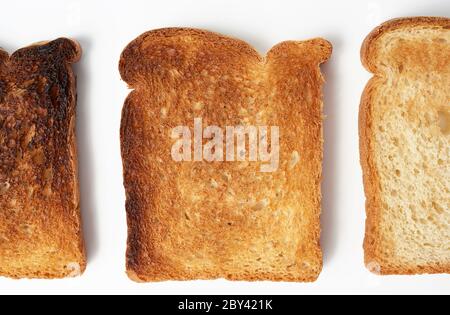 fette quadrate di pane a base di farina bianca di grano tostate in un tostapane, fondo bianco Foto Stock