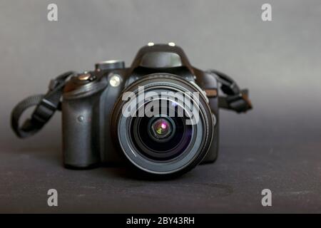 Fotocamera reflex digitale professionale moderna immagine chiave bassa. Fotocamera moderna con un obiettivo ad apertura molto ampia nella vista frontale. Foto Stock