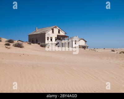 Kolmanskop Ghost Town vicino a vecchie miniere di diamanti nel sud della Namibia con le case devasted piene di sabbia. Foto Stock