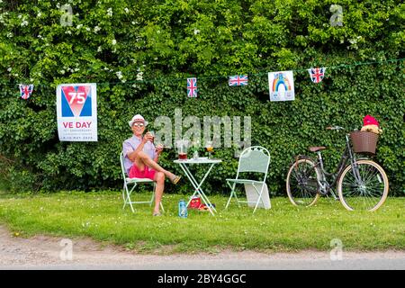 Membro del pubblico visto fuori casa sua aiutare a celebrare 75 anni dalla fine della seconda guerra mondiale. Visto con il bunting e una tipica bicicletta inglese. Foto Stock