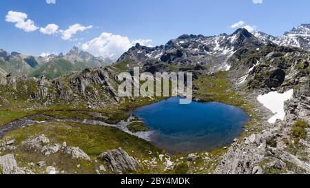 Il Lago Bleu a Chianale, lago di montagna nelle alpi italiane del Cuneo, Piemonte, di fronte alla famosa vetta del Monviso Foto Stock