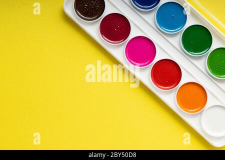 pulire la nuova tavolozza di acquerelli su uno sfondo di carta giallo, copyspace Foto Stock