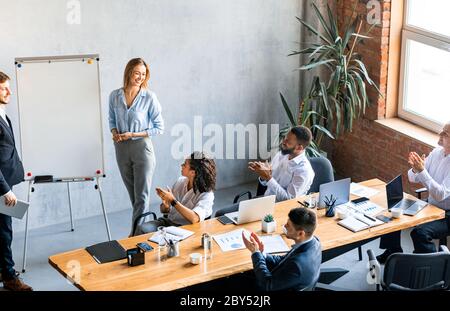 Colleghi che danno voce presentando una nuova idea ai colleghi in ufficio Foto Stock