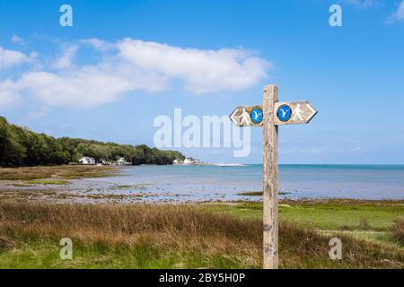 Indicazione per il sentiero costiero sul sentiero costiero intorno al salmarsh costiero a Red Wharf Bay (Traeth Coch), Isola di Anglesey, Galles, Regno Unito, Gran Bretagna Foto Stock