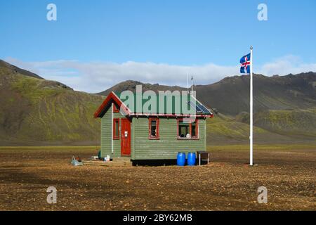 Piccola cabina con bandiera nel mezzo del paesaggio islandese Foto Stock