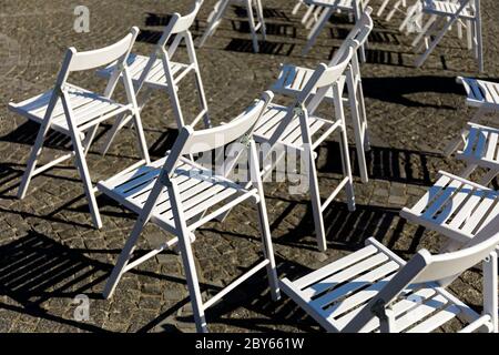 Simmetria dell'amore: File di sedie bianche pieghevoli sul prato prima di  una cerimonia di nozze in estate. Sedie bianche pieghevoli in un matrimonio  all'aperto con fiori Foto stock - Alamy