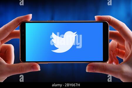 POZNAN, POL - 21 MAGGIO 2020: Smartphone con mani che mostra il logo di Twitter, un servizio americano di microblogging online e social networking Foto Stock