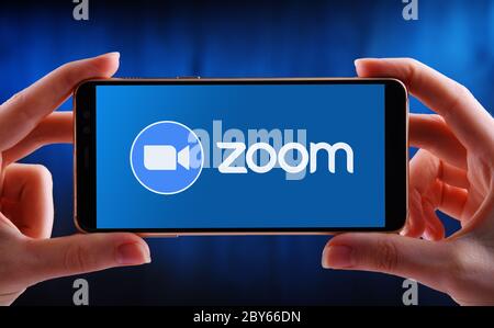 POZNAN, POL - 21 MAGGIO 2020: Smartphone con mani in mano che mostra il logo di Zoom, videotelefonia e servizi di chat online attraverso un peer-to-pe basato su cloud Foto Stock