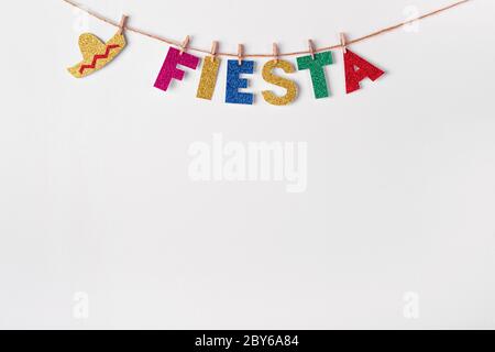 Parola Fiesta sui perni su sfondo bianco. Frammento di decorazione festosa fai da te di interni. Cinco de mayo celebrazione. Foto Stock