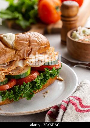 Sandwich di sottomarino tacchino con cetriolo, pomodoro e lattuga su un piatto Foto Stock