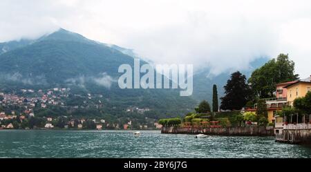 Vista panoramica del lago di Como con villaggi e montagne avvolti da nuvole. Torno. Italia. Foto Stock