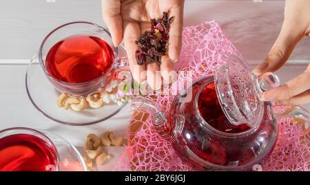 Una donna fa il tè. Tè rosso, ibisco, karkade, Rooibos. Cerimonia, tè pomeridiano, colazione. Tè, carcade. Orientale, accogliente, tradizione, giapponese, le Foto Stock