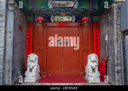 Porta rossa in hutong tradizionale zona residenziale a Pechino, Cina Foto Stock