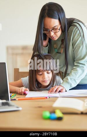 Madre aiutare mia figlia con i compiti Foto Stock