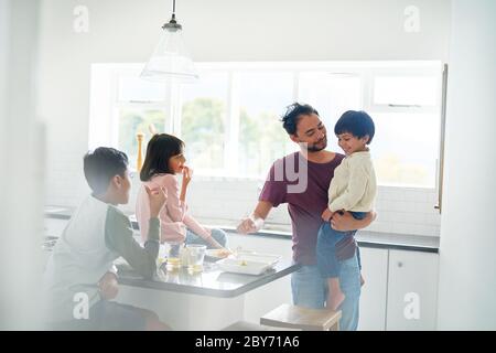 Padre e bambini che mangiano in cucina Foto Stock