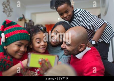 Felice famiglia che prende selfie Natale con smartphone Foto Stock