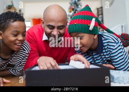 Padre e figli dono di Natale di apertura Foto Stock