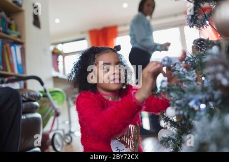 Ragazza decorare albero di Natale Foto Stock