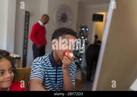 Ragazzo che mangia la mela a casa Foto Stock