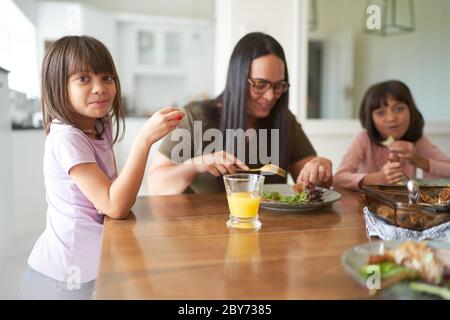 Madre e figlie mangiano il pranzo al tavolo Foto Stock