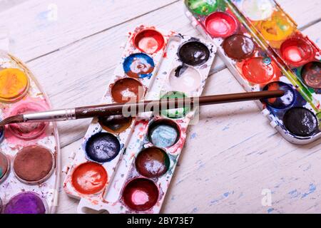 Acquerello professionale aquarell vernici in scatola con spazzole su vecchio asse di legno bianco Foto Stock