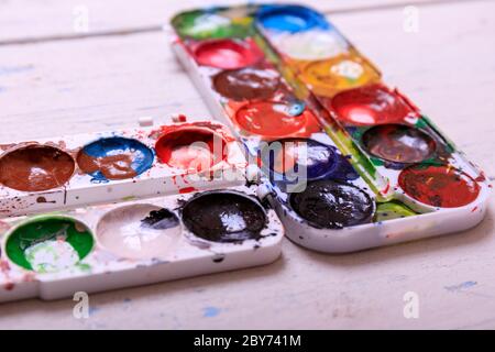 Acquerello professionale aquarell vernici in scatola con spazzole su vecchio asse di legno bianco Foto Stock