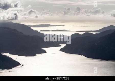 Incredibile vista panoramica del tramonto dal Monte Hellandsnuten alle silhouette delle catene montuose e Sandsfjord e l'Oceano. Norvegia. Foto Stock