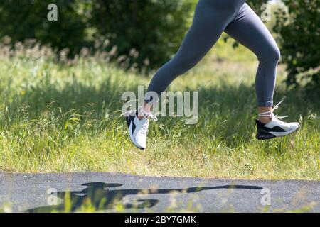 Donna runner in scarpe da running closeup di gambe sportive donna. Jogging femminile Foto Stock