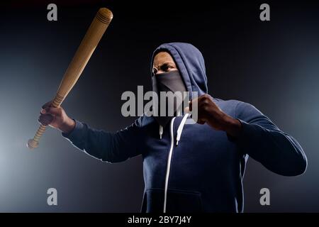 Profilo foto laterale di arrabbiato furioso afro americano ragazzo sollevare pugno baseball battuta pronta fermare discriminazione razzista usura maglione bandanna isolato Foto Stock