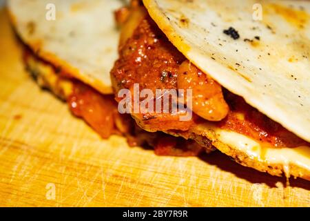 Quesadilla con manzo macinato, salsiccia, fagioli rossi, mais dolce, cipolla e salsa di pomodoro. Un pasto tradizionale messicano. Primo piano Foto Stock