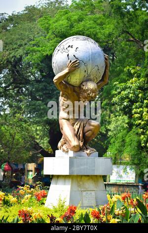Statua dell'Atlante allo zoo di Alupur a Kolkata, che è stato costruito circa 200 anni fa. Atlas era il dio Titan che ha dato il cielo aloft. Foto Stock