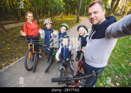 Il tema famiglia sport attività ricreative all'aperto. grande famiglia Caucasian 6 persone mamma e papà di 4 bambini tre fratelli e la sorella in bici nel Parco su Foto Stock