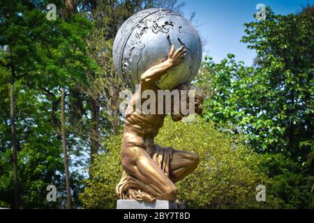 Statua dell'Atlante allo zoo di Alupur a Kolkata, che è stato costruito circa 200 anni fa. Atlas era il dio Titan che ha dato il cielo aloft. Foto Stock