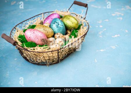 Primavera Pasqua sfondo per le vacanze. Composizione pasquale con uova di Pasqua colorate sul muschio in cestino. Vista dall'alto Foto Stock