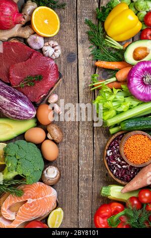 Cibo sano di fondo. Verdure fresche, frutta, fagioli, carne e pesce su tavola di legno. Cibo sano, cibo equilibrato, dieta e concetto di alimentazione sana. Foto Stock